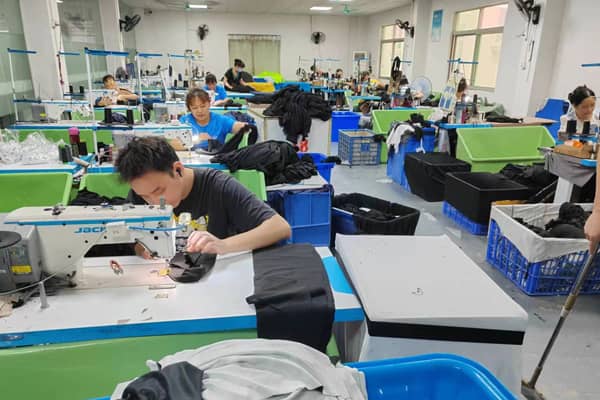 Factory floor with workers cutting and assembling equestrian gear